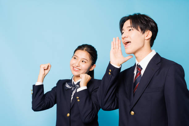 Asian teenagers in high school uniform with cheering gesture