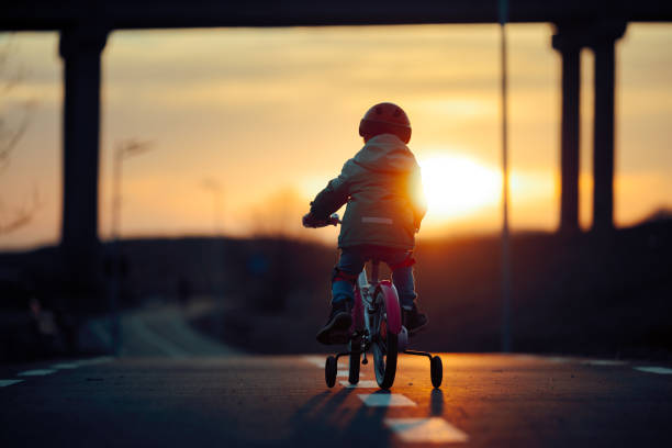 Active kid pedaling on her bicycle in the evening