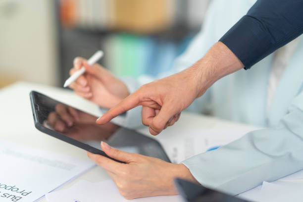 istock Two people collaborating on a tablet, showcasing teamwork and technology in a professional setting. 2197335254