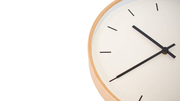 istock A close-up view of a modern clock with a wooden frame, featuring clean black hands and a minimalist design. 2197335361
