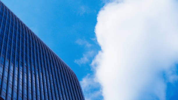 Elegant curves of modern architecture against a vibrant blue sky with dynamic clouds, offering a striking balance of innovation and natural beauty. ideal for contemporary design visuals