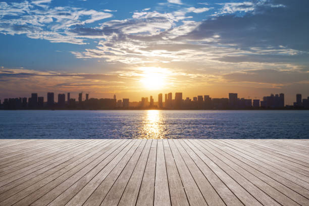 istock Empty wooden viewing platform with modern urban skyline and dramatic sky during sunset 2197337846