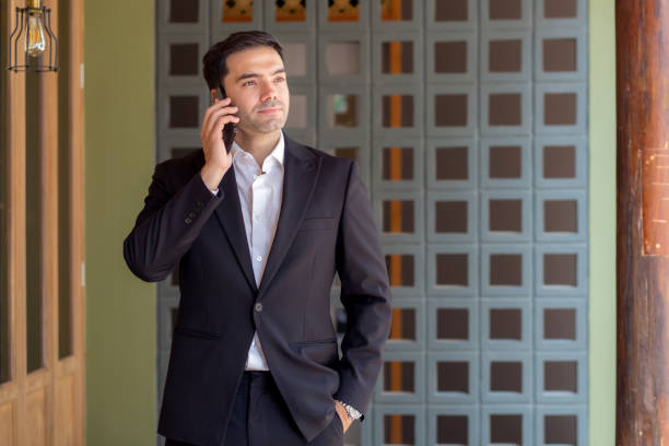 istock Portrait caucasian businessman standing and talking on smart phone with confident expression outside building, business man speaking on smartphone with expression, business and communication. 2197339975