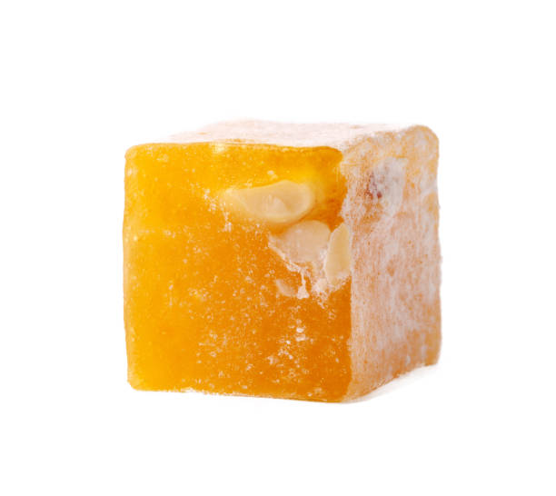 istock Yellow fruit-flavored confectionary cube with nut pieces on a white background 2197342746