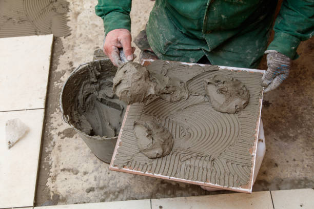 istock A man is holding a trowel and pouring concrete into a square mold 2197342958