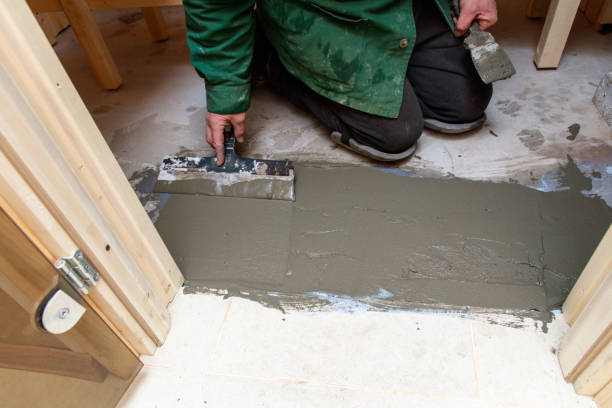 istock A man is laying on the floor and using a trowel to apply cement 2197342985
