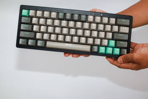 istock Close up view of a mechanical keyboard held in two hands against white background 2197346726
