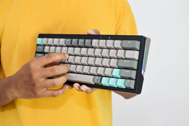 istock A person holds a black keyboard with gray and blue keys while pressing keys 2197347036