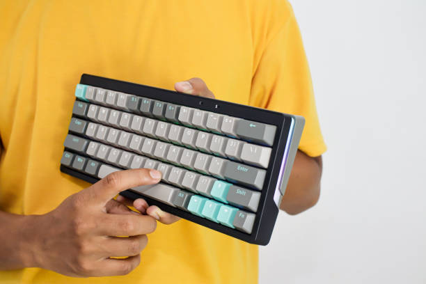 istock Person holding a black and grey computer keyboard with light blue keys 2197347160