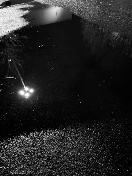 istock puddle reflection of streetlamp at night 2197348425