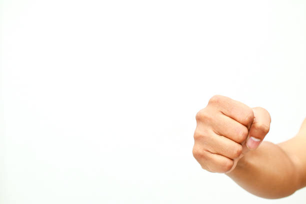 A clenched human fist against white background, conveys the meaning of aggression and strength.