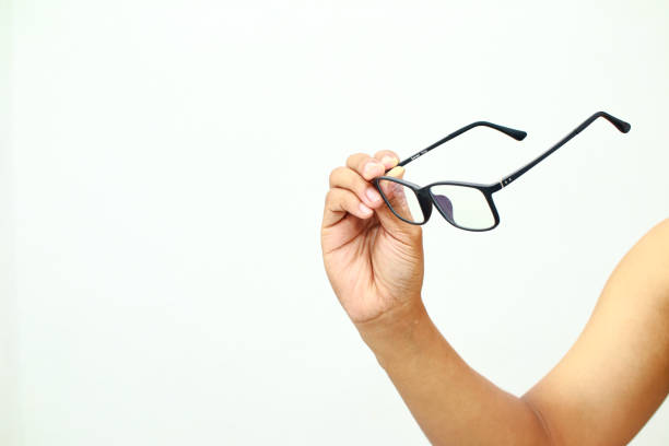 istock Person hand holding reading glasses isolated on plain white background with copy space 2197349082