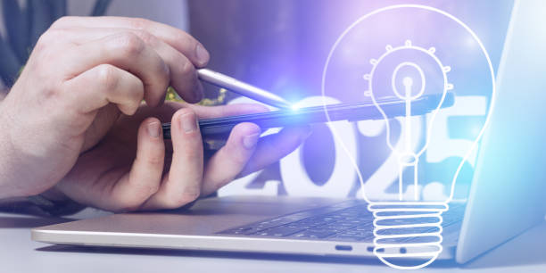 istock Futuristic Innovation Concept with Stylus Interaction on Smartphone, Lightbulb Icon Symbolizing Ideas, and a Modern 2025 Workspace 2197350830