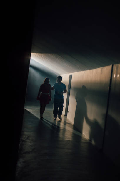 istock Moody And Dark Coach Walking His Athlete Down The Hall 2197351139
