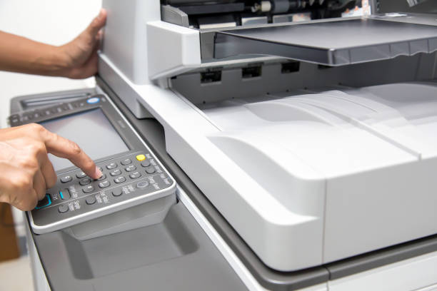 istock Closeup hand press button to using the photocopier or xerox machine is office work tool printer equipment in copy room for scanning document and print a paper. 2197352109
