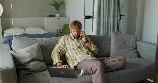 istock A man uses a laptop at home 2197352118