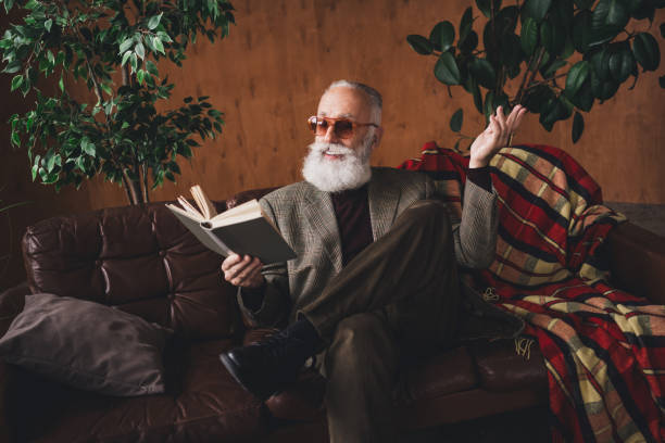 istock Elderly gentleman reading a book in a retro-inspired interior setting with stylish furnishings and natural light 2197352238