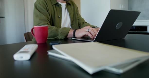 istock A man uses a laptop at home 2197353242