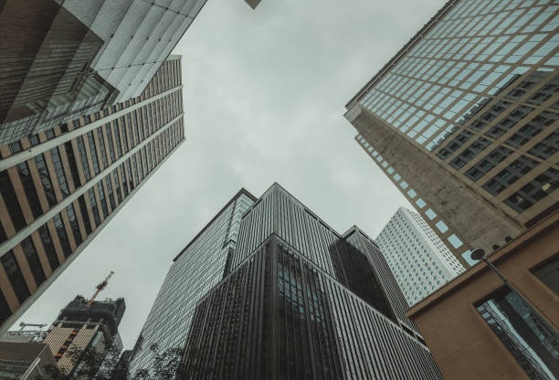 istock A low-angle, close-up view of towering skyscrapers in Hong Kong, their imposing structures filling the frame against an overcast sky. 2197354717