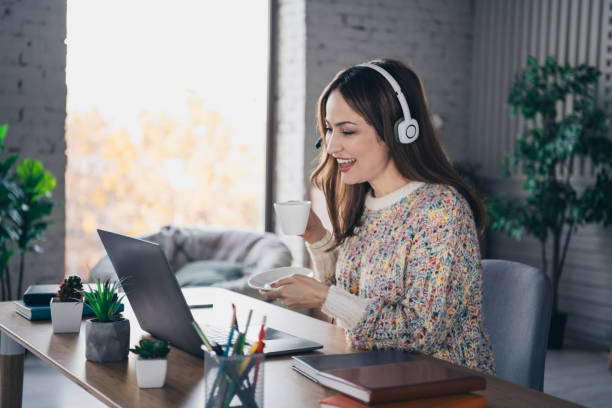 istock Charming woman enjoying coffee while working remotely at home office 2197355610