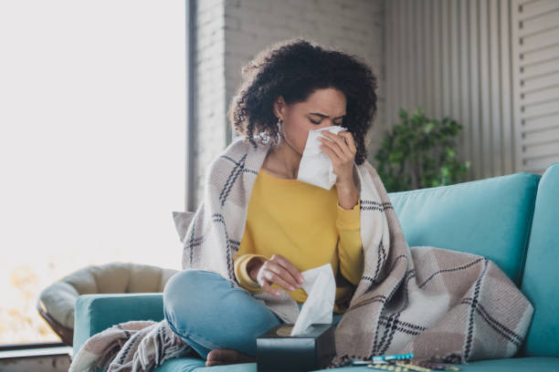 istock Young woman with tissue on couch feeling unwell and resting indoors 2197357779