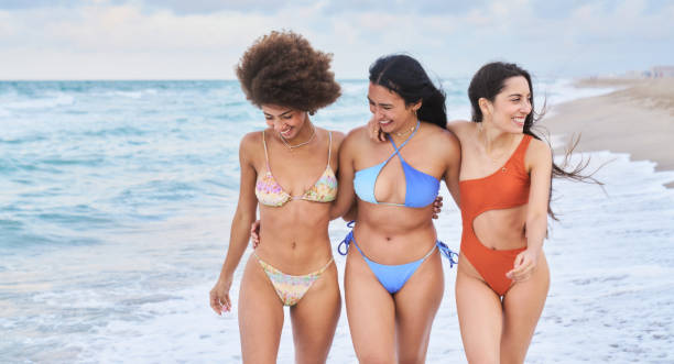 istock Three young women walking on the beach, enjoying summer vacation 2197358542