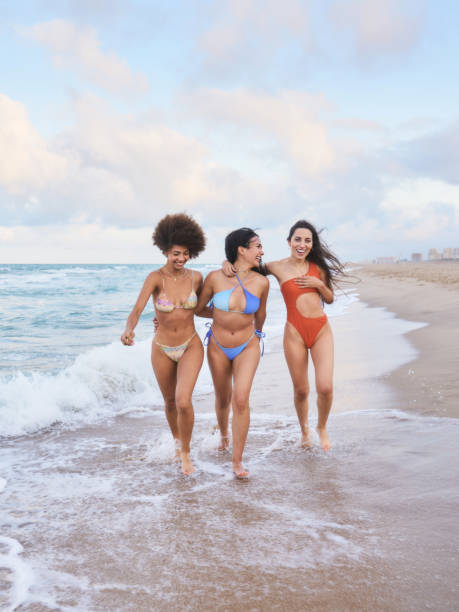 istock Three young women walking on the beach, enjoying summer vacation 2197358543