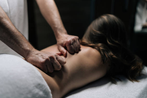 istock Close-up hands of masseur male performing deep tissue technique on female back, targeting muscle tension and promoting wellness during bodywork session 2197359985
