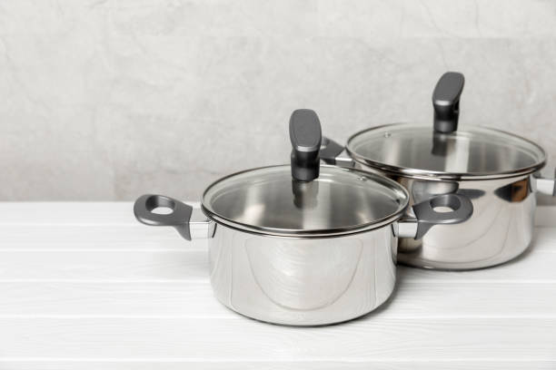 istock Stainless steel saucepan on light kitchen background. Modern saucepan. Kitchenware. Cooking pot. Cooking concept. Mockup. Space for text. Copy space. 2197360571