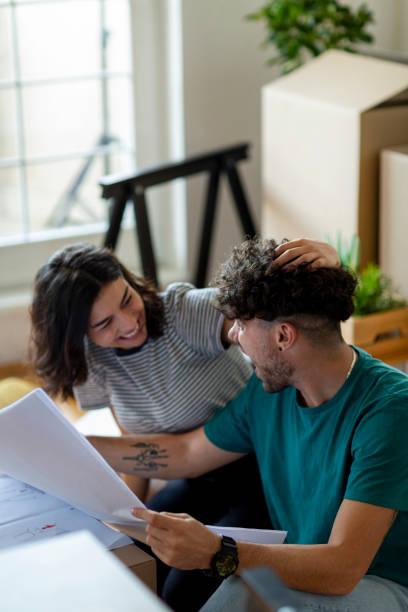 istock Young couple reading plans in new home 2197361964