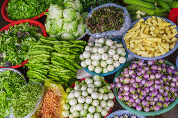 Various vegetables and herbs on the market in baskets. Asian vegetables. Vietnam Market