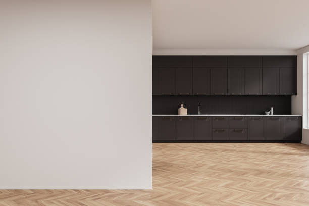 istock Minimalist kitchen with dark cabinets and empty white wall for mockup or design template layout in modern space. 3D Rendering 2197363801