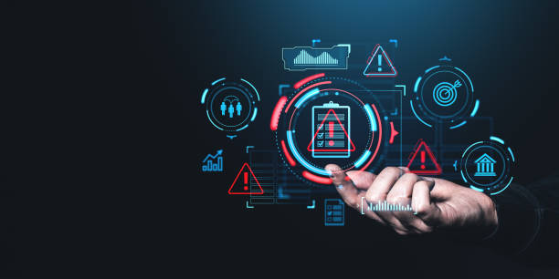 istock Hand interacting with futuristic digital icons representing risk management and safety on a dark background. 2197364747
