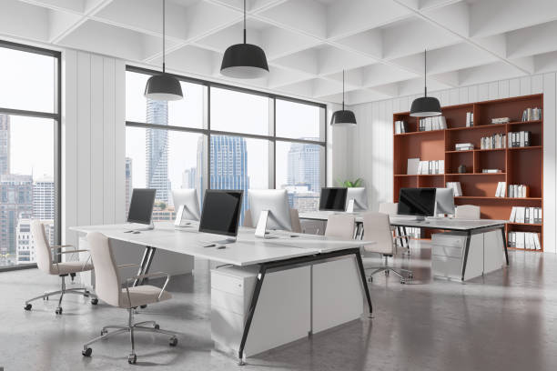 istock Modern open office interior with desks, computers, and large windows overlooking urban skyline. Contemporary design workspace. 3D Rendering 2197364861