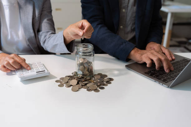 istock concept with saving money, accountant working on desk in home using calculator and laptop to calculate budget. 2197369478