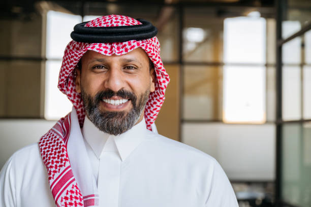 istock Confident mature Middle Eastern businessman with beard, wearing keffiyeh, smiling towards camera 2197369846