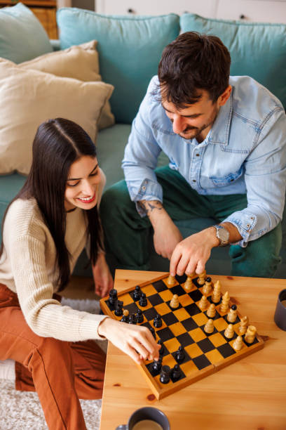 istock Couple spending leisure time at home playing chess 2197370696