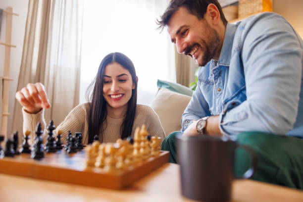 istock Multi-ethnic couple playing chess at home 2197370739