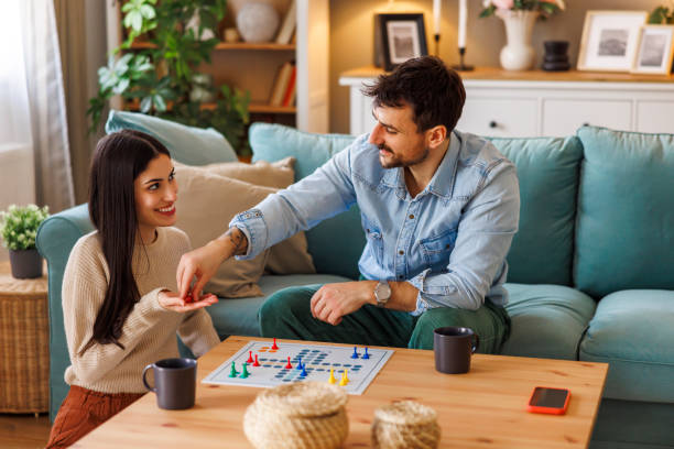 istock Couple playing ludo board game at home 2197371104