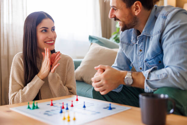 istock Couple relaxing at home playing ludo board game 2197371142