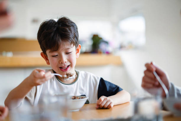 istock Happy Child Enjoying Meal at Home Kitchen Table 2197371676