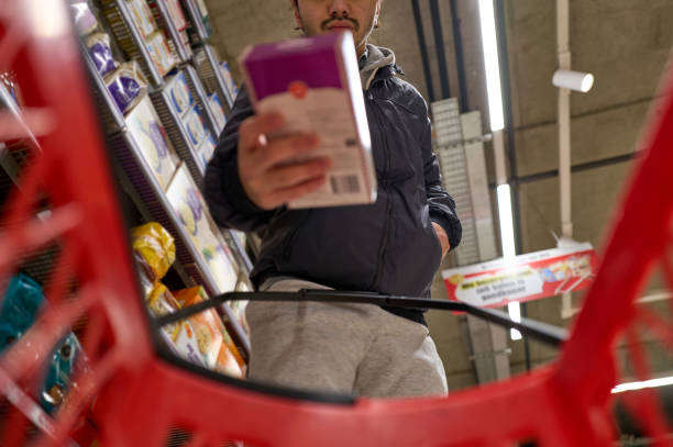 istock Young man reading product information while shopping in supermarket 2197374894