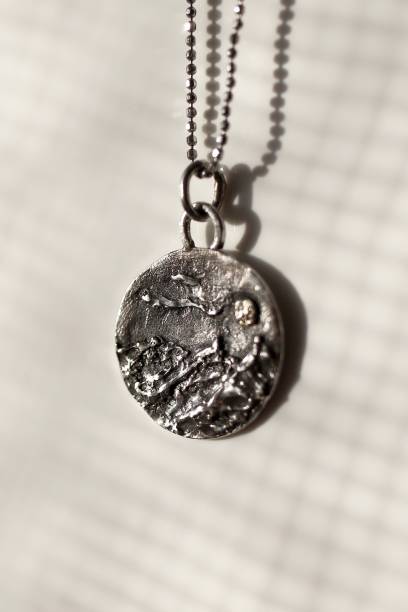 istock Silver pendant with mountain range and moon design on a white background. Handcraft precious item. 2197377678