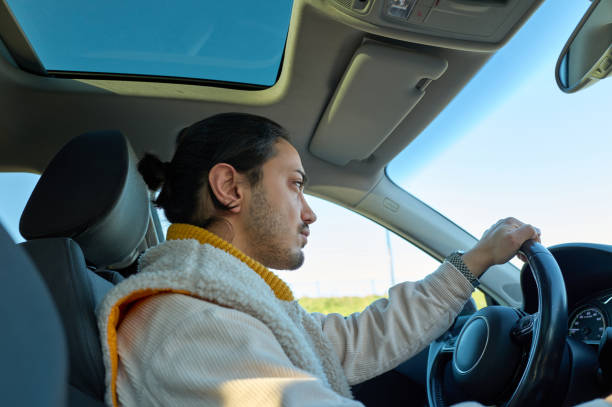 istock Young man driving modern car in the city 2197380632