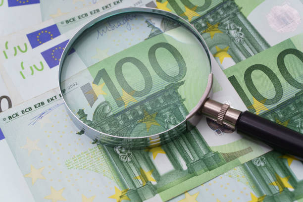 istock Magnifying glass on hundred euro banknotes 2197381126