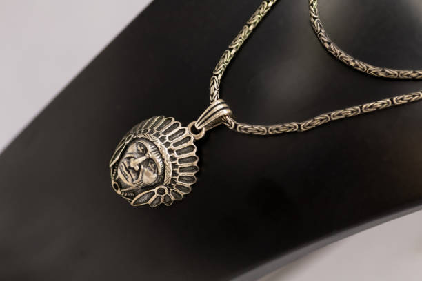 A finely crafted silver pendant showcasing a Native American chief with an intricate headdress