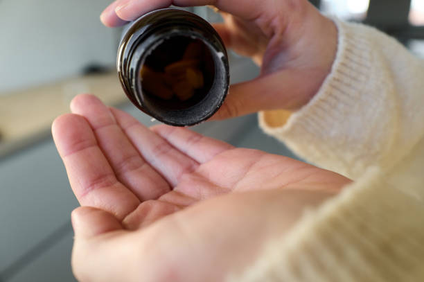 istock Close up, Young woman takes a pill from a pill box. 2197383164