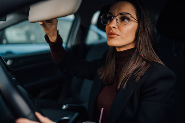 istock Businesswoman adjusting sun visor while driving modern car 2197384824