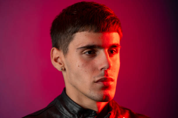 istock Young man posing with red and purple lights creating dramatic portrait 2197384869