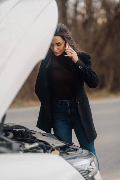 istock Businesswoman calling for help with broken car on roadside 2197384906